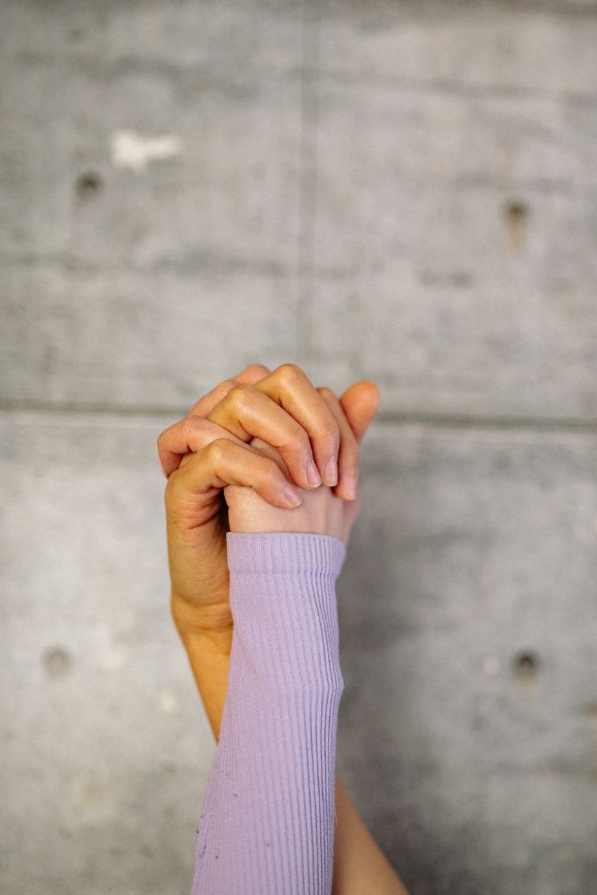 Two hands clasped together, symbolising care and support